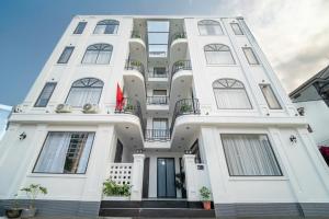 a white building with a lot of windows at Cát Boutique Hotel in Dong Hoi