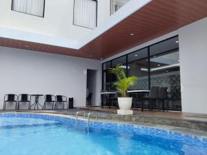 a pool in a hotel with chairs and a table at Front One Luxe Hotel Solo in Solo