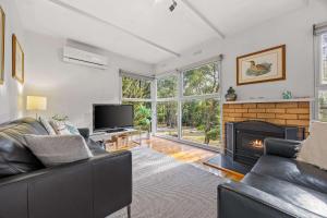 a living room with a couch and a fireplace at Wattletree Cottage Halls Gap in Halls Gap +18 photos