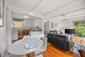 a kitchen and living room with a table and a couch at Wattletree Cottage Halls Gap in Halls Gap