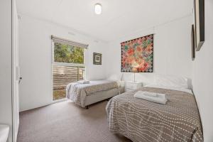 a bedroom with two beds and a window at Wattletree Cottage Halls Gap in Halls Gap