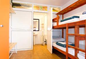 a room with two bunk beds and a bathroom at Hostel albergue Paradiso in Hinojedo