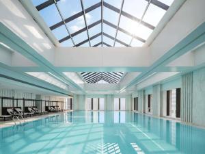 a swimming pool with a skylight in a building at Fairmont Wuhan in Wuhan