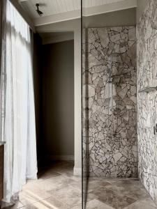 a glass shower in a bathroom with a stone wall at Frogs Pond in Red Hill +61 photos