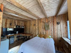 a bedroom with a bed in a wooden room at Cabañas Refugio del Lago in El Cerrillo