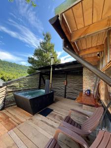 a patio with a hot tub and chairs on a deck at Cabañas Refugio del Lago in El Cerrillo