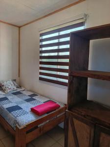 a small bedroom with a bed and a window at Cabaña Rústica en Papudo in Papudo +24 photos