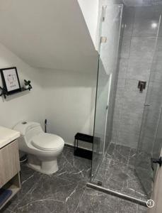 a bathroom with a toilet and a glass shower at 10 Caribe, tranquilidad y Casa Familiar in Rodadero +9 photos