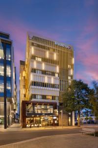 a tall building with lights on in a city at BreakFree on Cashel, an Accor Hotel in Christchurch