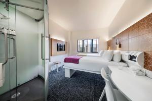 a hotel room with a bed and a shower at BreakFree on Cashel, an Accor Hotel in Christchurch +37 photos