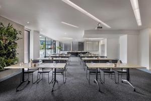 a cafeteria with tables and chairs in a room at BreakFree on Cashel, an Accor Hotel in Christchurch