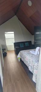 a bedroom with a bed and a wooden floor at Cabaña jacuzi interno in El Chocho