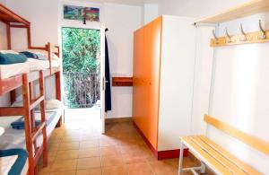 Habitación con literas y puerta con ventana en Hostel albergue Paradiso en Hinojedo