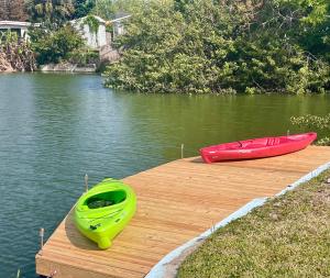two kayaks sitting on a wooden dock on a lake at Mia Rose in South Daytona