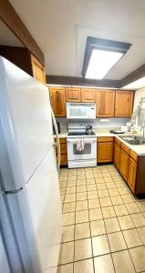 a kitchen with a white refrigerator and a stove at Mia Rose in South Daytona