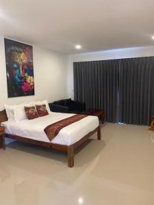 a bedroom with a bed and a large window at Isaan Country Retreat in Mukdahan