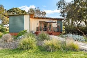 a small house with a porch in a garden at Phillip Island Resort Villa 148 Amazing Views in Cowes