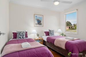 two beds in a room with a window at Phillip Island Resort Villa 148 Amazing Views in Cowes