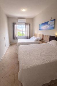 a hotel room with three beds and a window at Apartamento completo Excelente localização Centro in Canindé