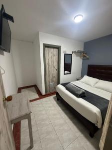 a bedroom with a bed and a table in it at CASA HOTEL VICTORIA Av 30 in Bogotá