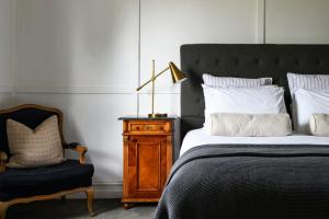 a bedroom with a bed and a chair and a lamp at Little Wombat Daylesford in Daylesford