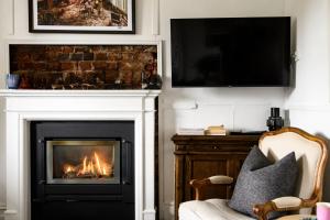 a living room with a fireplace and a tv at Little Wombat Daylesford in Daylesford