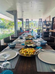 a long wooden table with plates of food on it at Cote Resort in Dipaculao