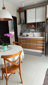 a kitchen with a table and a kitchen with a refrigerator at Apartamento de 2 quartos no centro de Garopaba in Garopaba +18 photos