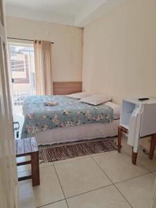 a small bedroom with a bed and a window at Pousada Morada in Aparecida +5 photos
