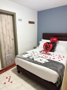 a bedroom with a bed with a red heart on it at CASA HOTEL VICTORIA Av 30 in Bogotá
