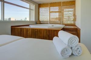 a bedroom with a tub and a bed with towels at Park Inn by Radisson Berrini in São Paulo