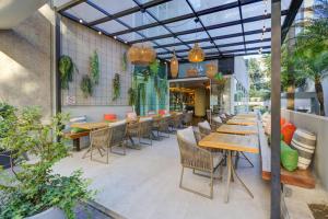 a restaurant with wooden tables and chairs and plants at Park Inn by Radisson Berrini in São Paulo