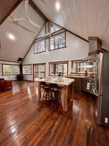 a large kitchen with a table and a refrigerator at The Founder - Iconic Rockhouse Cabin in Campton