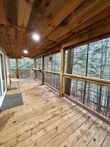 an empty screened in porch with wood floors and windows at The Founder - Iconic Rockhouse Cabin in Campton +37 photos