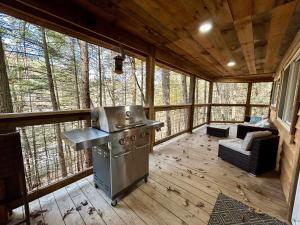 a screened in porch with a stove in a cabin at The Founder - Iconic Rockhouse Cabin in Campton
