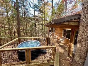 a hot tub on the deck of a tree house at The Founder - Iconic Rockhouse Cabin in Campton