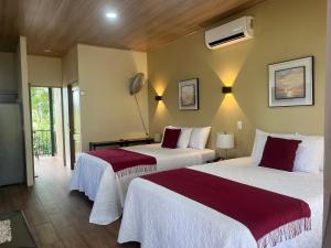 a hotel room with two beds and a fan at Cabañas y Senderos Finca El Triunfo in Los Chiles