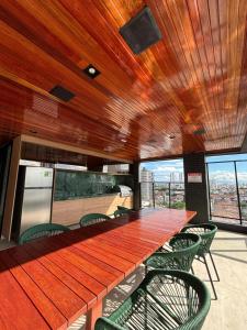 a long wooden table and chairs in a building at Flat Exclusivo com Rooftop e Piscina in Campina Grande