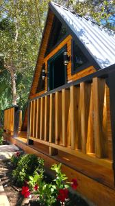 a cabin with a wooden fence and flowers at Cumbre Verde Alpine Villa in Monción +5 photos
