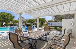 a patio with a table and chairs next to a pool at Beach Condo in Dana Point