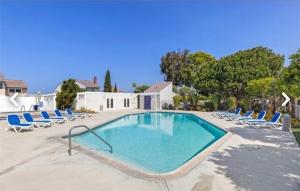 a swimming pool with lounge chairs and a swimming pool at Beach Condo in Dana Point