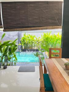 an outdoor dining area with a table and a swimming pool at Villa Solas Legian in Legian