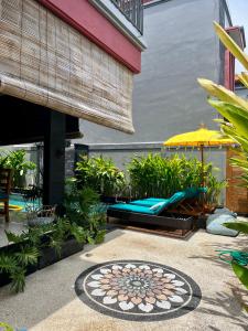a patio with a table and chairs and an umbrella at Villa Solas Legian in Legian