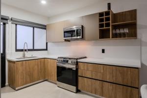 a kitchen with a stove and a microwave at Casa Parota in Naranjo