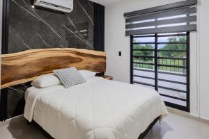 a bedroom with a white bed and a large window at Casa Parota in Naranjo +26 photos