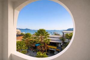 an arched window in a building with palm trees at Inn Room Hotel Bajo in Labuan Bajo