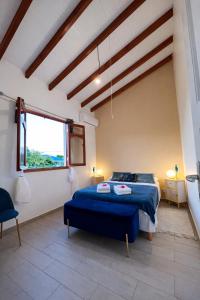 a bedroom with a blue bed and a window at Villa Belle Ile en Mer in Capesterre