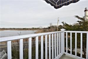 a white railing on a porch with a lighthouse at Gem-By-The-Sea in Cape May Point