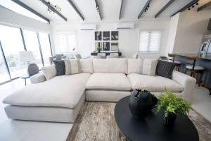 a living room with a white couch and a table at Avaya Oasis - Villa Trinidad in Carenage