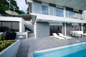 a house with a swimming pool next to a house at Avaya Oasis - Villa Trinidad in Carenage